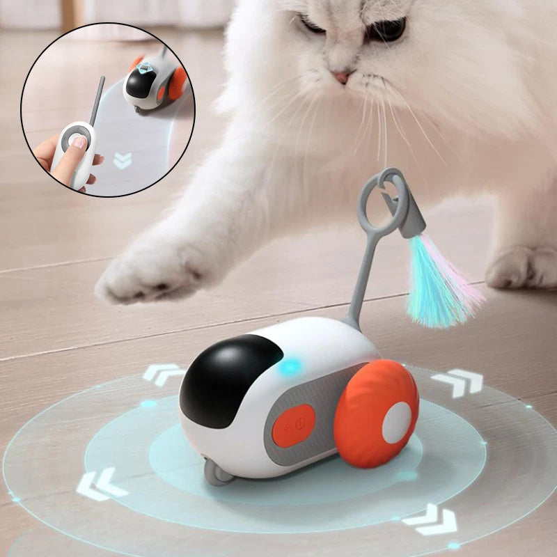 A white cat with a pink nose touching a remote-controlled cat toy car. The toy car is on a wooden floor, and there is an inset image showing the toy in action.