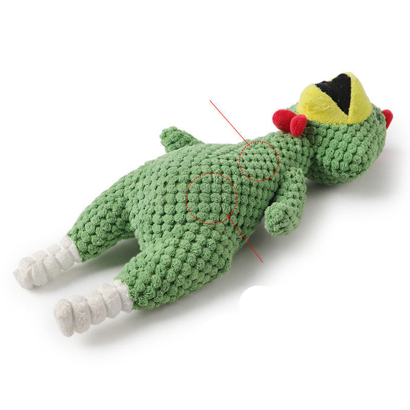 Green crochet toy with a yellow hat and red pom-poms on a white background
