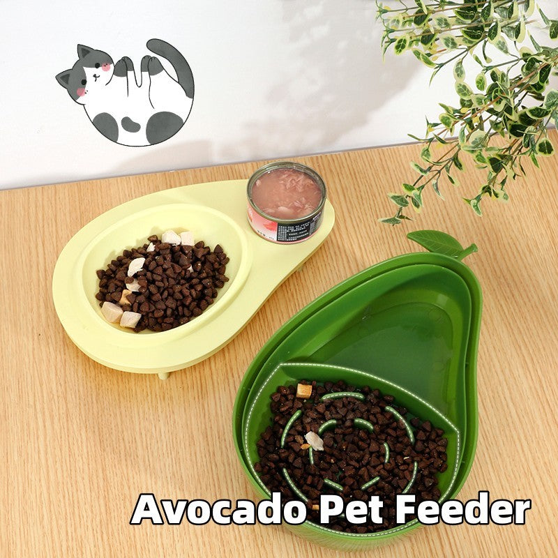 Avocado-shaped pet feeder bowls for cats and dogs on a wooden table with cat food and greenery decoration.
