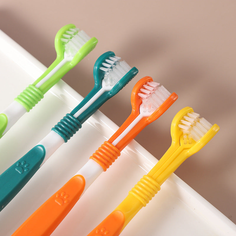 Set of four double-headed pet toothbrushes in green, blue, orange, and yellow – dental care for dogs and cats.