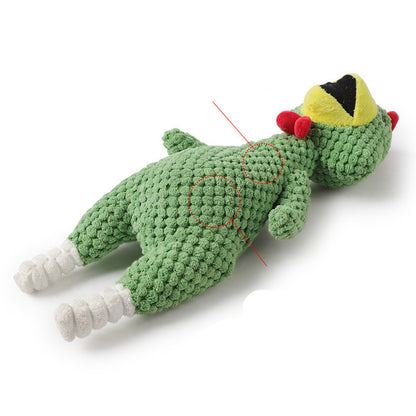 Green crochet toy with a yellow hat and red pom-poms on a white background