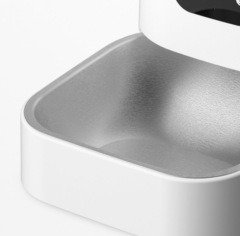 Close-up of a metallic kitchen sink corner with a white cabinet.